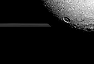 Na zdjęciu, Dione znajduje się na tle pierścieni Saturna. Widok ten został uchwycony podczas ostatniego, bliskiego przelotu sondy nad lodowym księżycem..jpg
